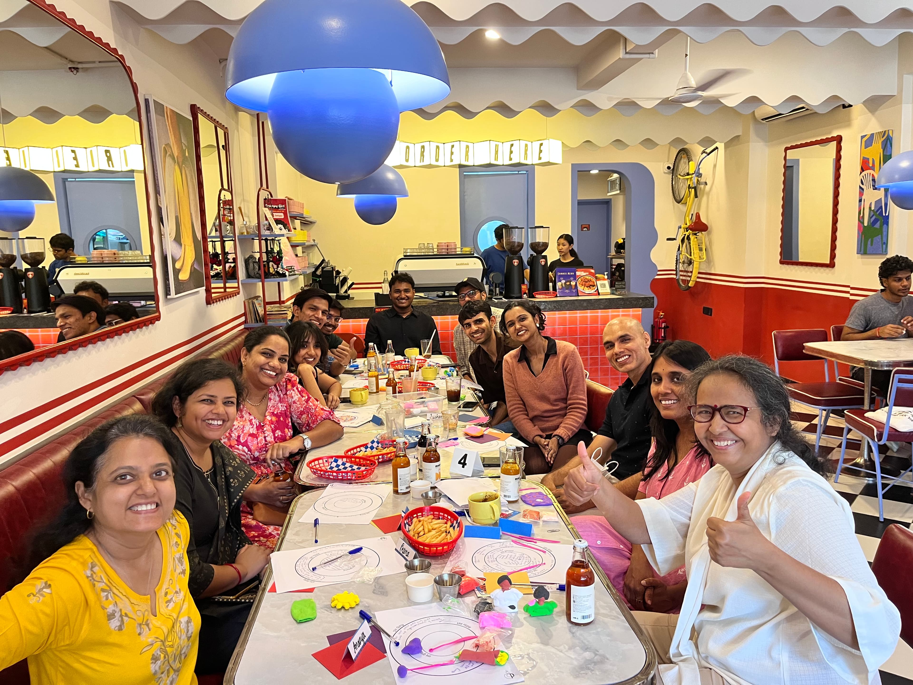 A full table of participants at a House Of Prama session in a Bengaluru cafe.
